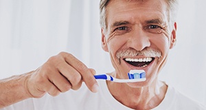 Man brushing his All-on-4 dental implants