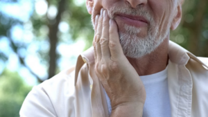 Man rubbing his jaw because gum disease is causing discomfort